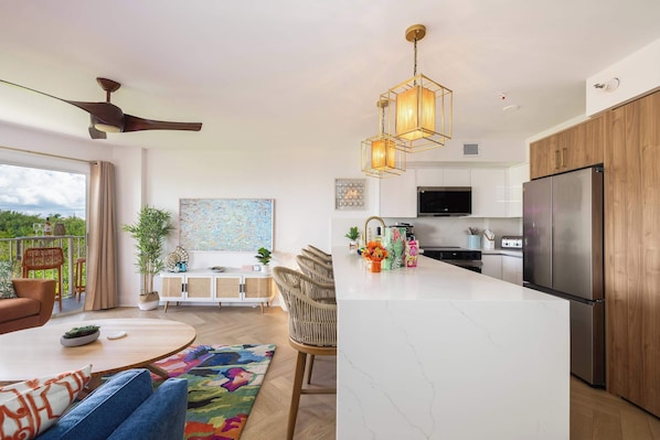 A modern kitchen with a central island, built-in appliances, and a dining area with a round table and chairs.