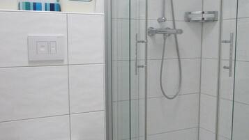 Een douche, een haardroger, handdoeken, toiletpapier