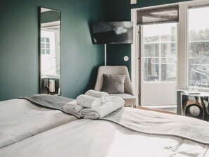 A hotel room with a bed, a chair, a TV, and a view of the outdoors. - 4 Star Holiday Home in Hisings Backa (Hisings Backa)