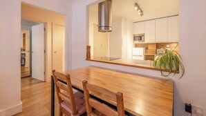 Una cocina moderna con gabinetes blancos, una campana extractora de acero inoxidable y un microondas.