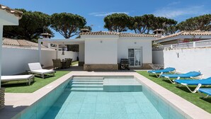 A swimming pool with lounge chairs and a patio area.