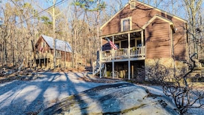 A rustic cabin with a porch, surrounded by trees and a stone pathway. - 2 Cabins on 3 Acres | Hot Tubs & Trails (Mentone)