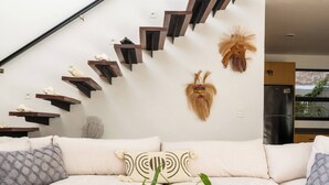 Una sala de estar moderna con una mesa de centro de madera, un sofá color beige y una escalera con escalones de madera.