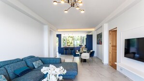 Uma sala de estar moderna com sofá, área de refeições e televisão.