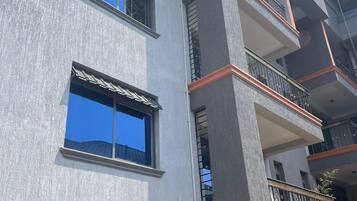 A multi-story building with balconies, large windows, and a textured facade.