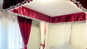 A bed with a white headboard and footboard, a wooden frame, and a tufted headboard. - Munyonyo 2bedroom Joy Apartments (Kampala)