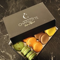 Una caja de macarons de Charlotte sobre un fondo de mármol.