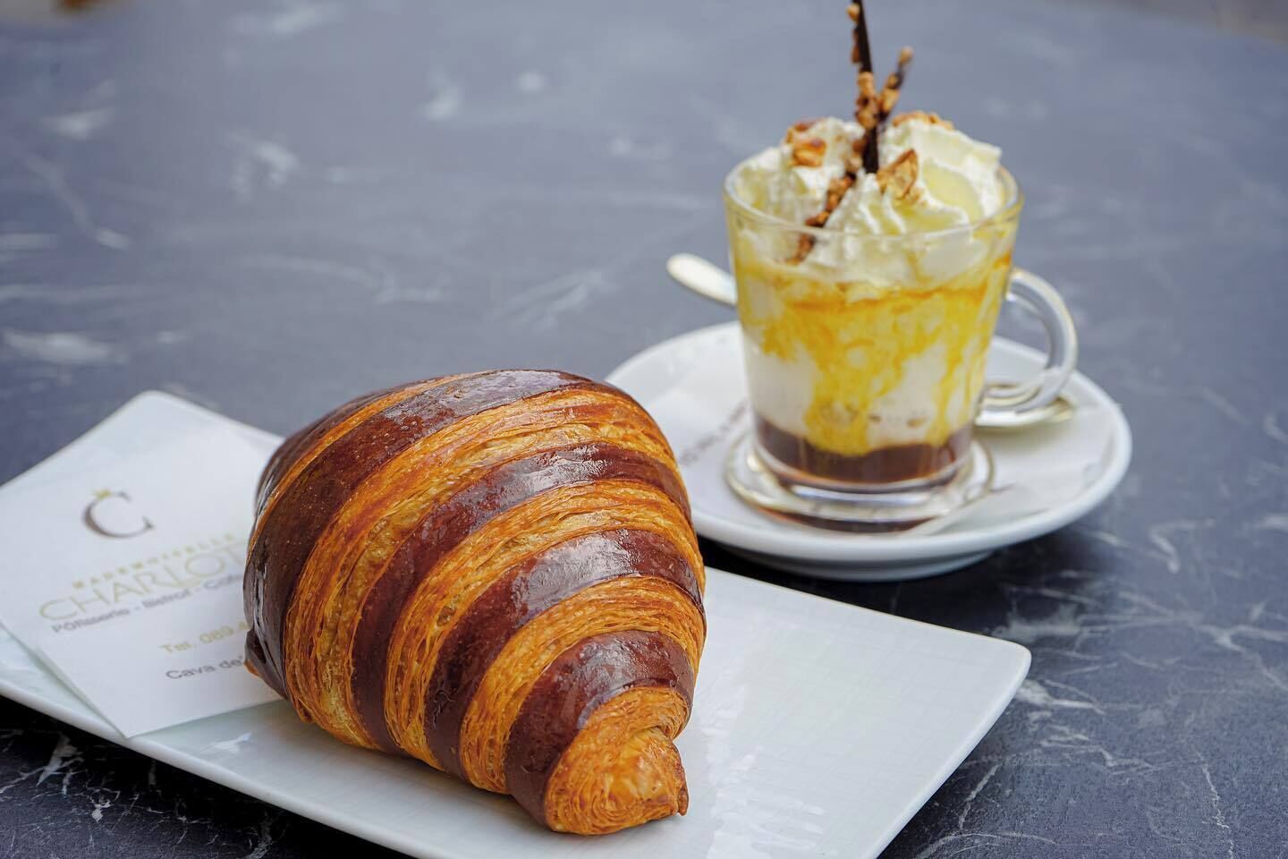 A croissant and a dessert on a table.