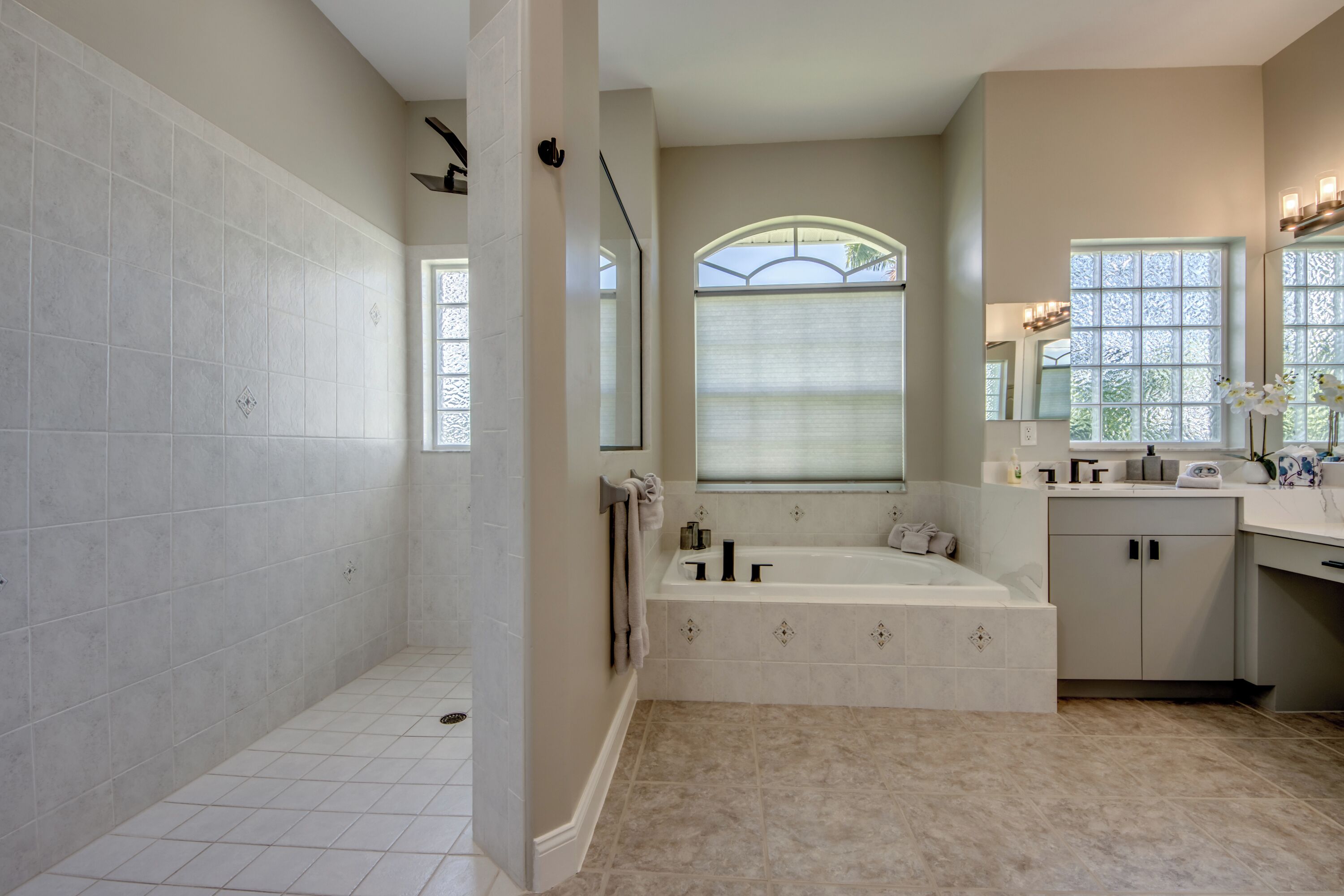 A spacious bathroom with a large bathtub, a walk-in shower, and a vanity with a mirror.