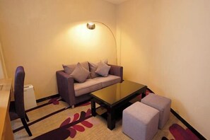 A small living area with a sofa, a coffee table, and a lamp.