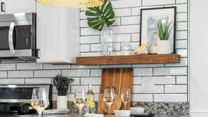 Una cocina moderna con una isla central, una lámpara colgante y un microondas.