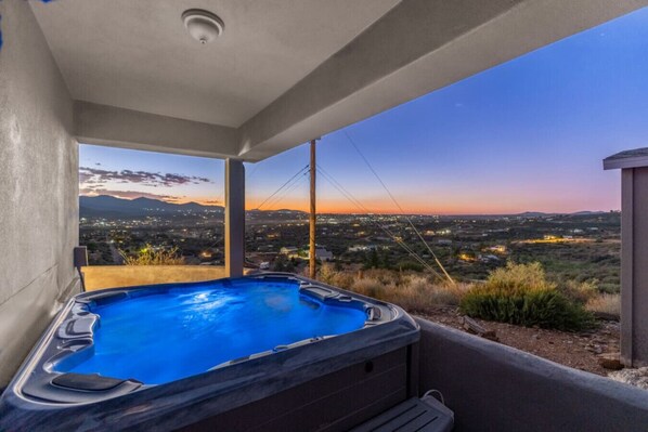 Un jacuzzi con vista a la ciudad al atardecer.