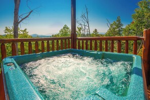 Relax in the hot tub on the elevated deck, taking in the breathtaking views of the surrounding landscape.