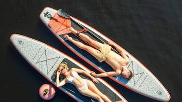 Zwei Personen liegen auf Surfbrettern im Wasser.