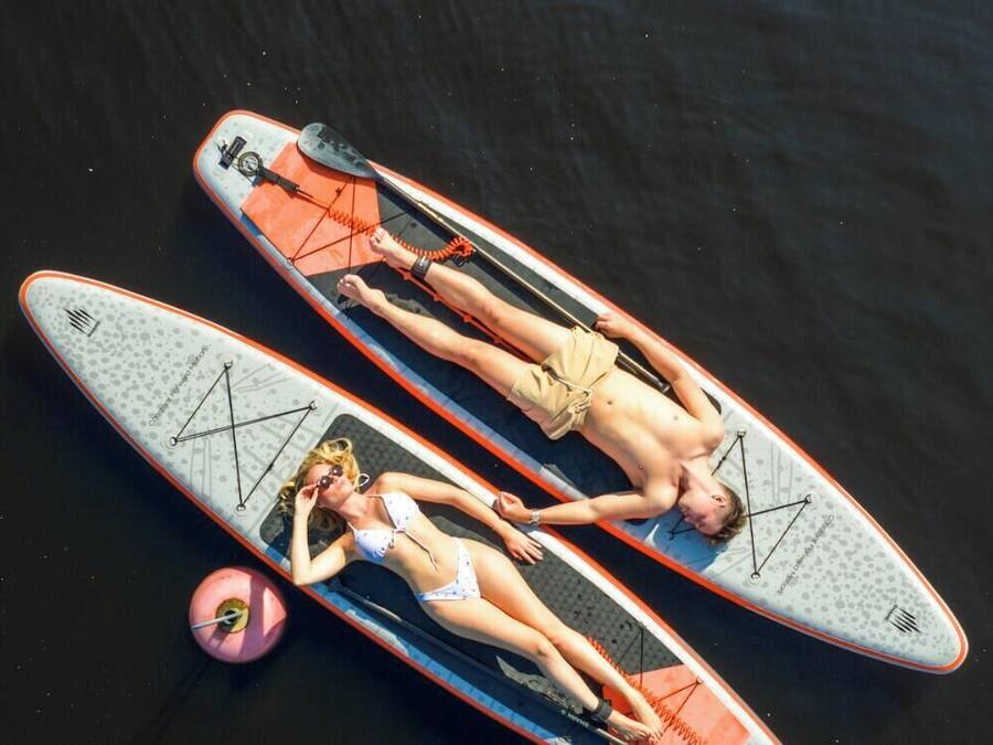 Zwei Personen liegen auf Surfbrettern im Wasser.