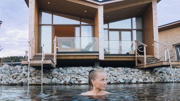A modern wooden building with large windows and a pool in front. - Bella Lake Resort (Kuopio)