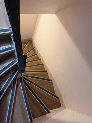 A spiral staircase with wooden steps and metal railings. - Modern Apartment - 2BD/5P - Sentier/Montorgueil (Paris)