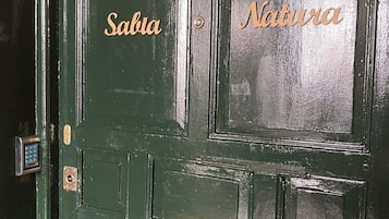 Eine grüne Tür mit den eingravierten Wörtern "Sabia" und "Natura".