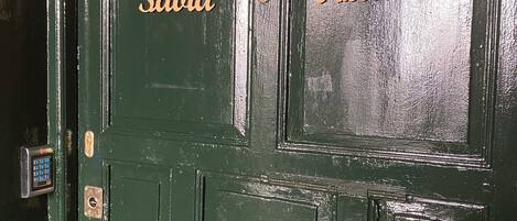 A green door with the words "Sabia" and "Natura" carved into it.