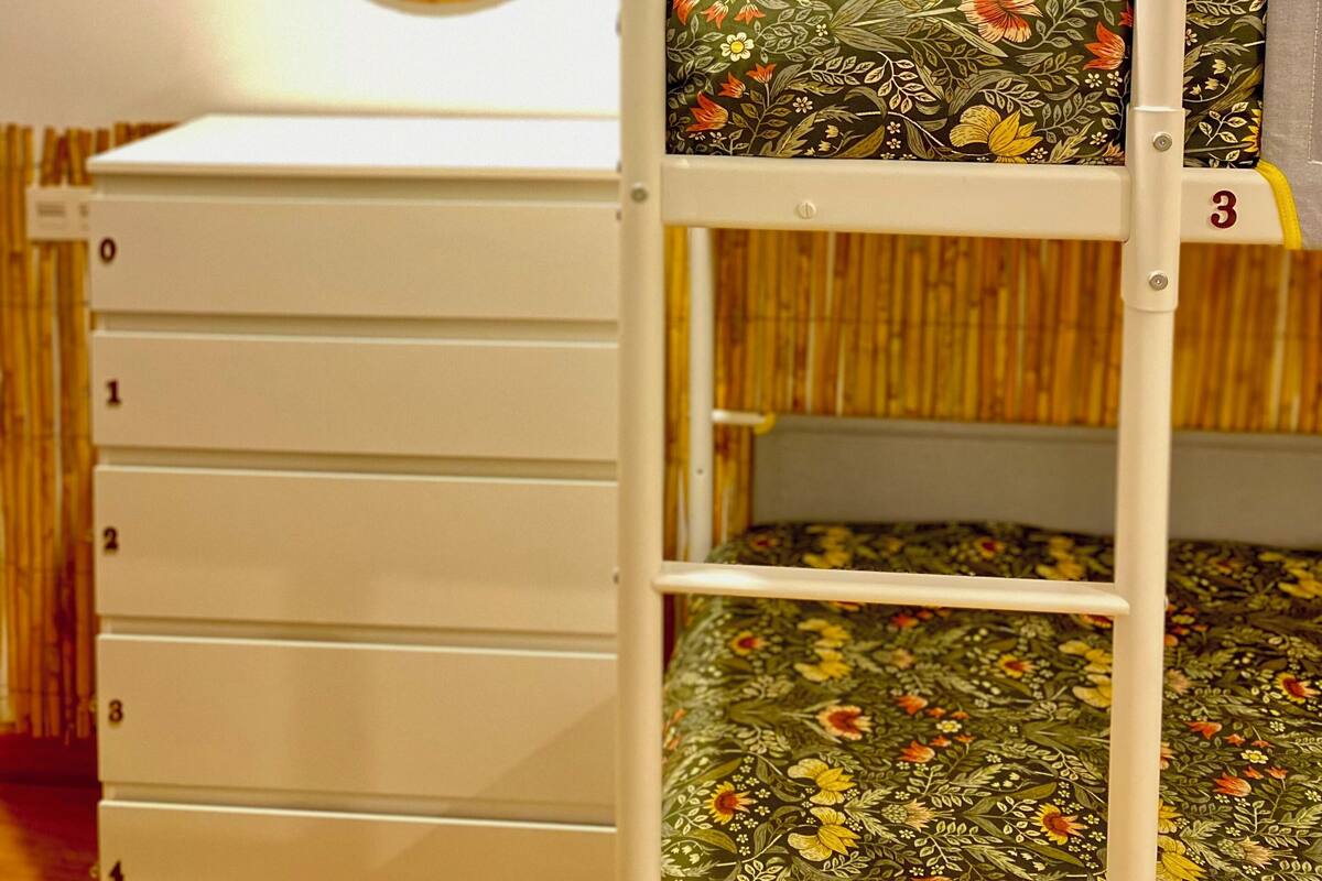 A bunk bed with a lower bunk and a storage unit below.