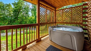 Une terrasse en bois avec un jacuzzi, des rampes en bois et un treillis décoratif.