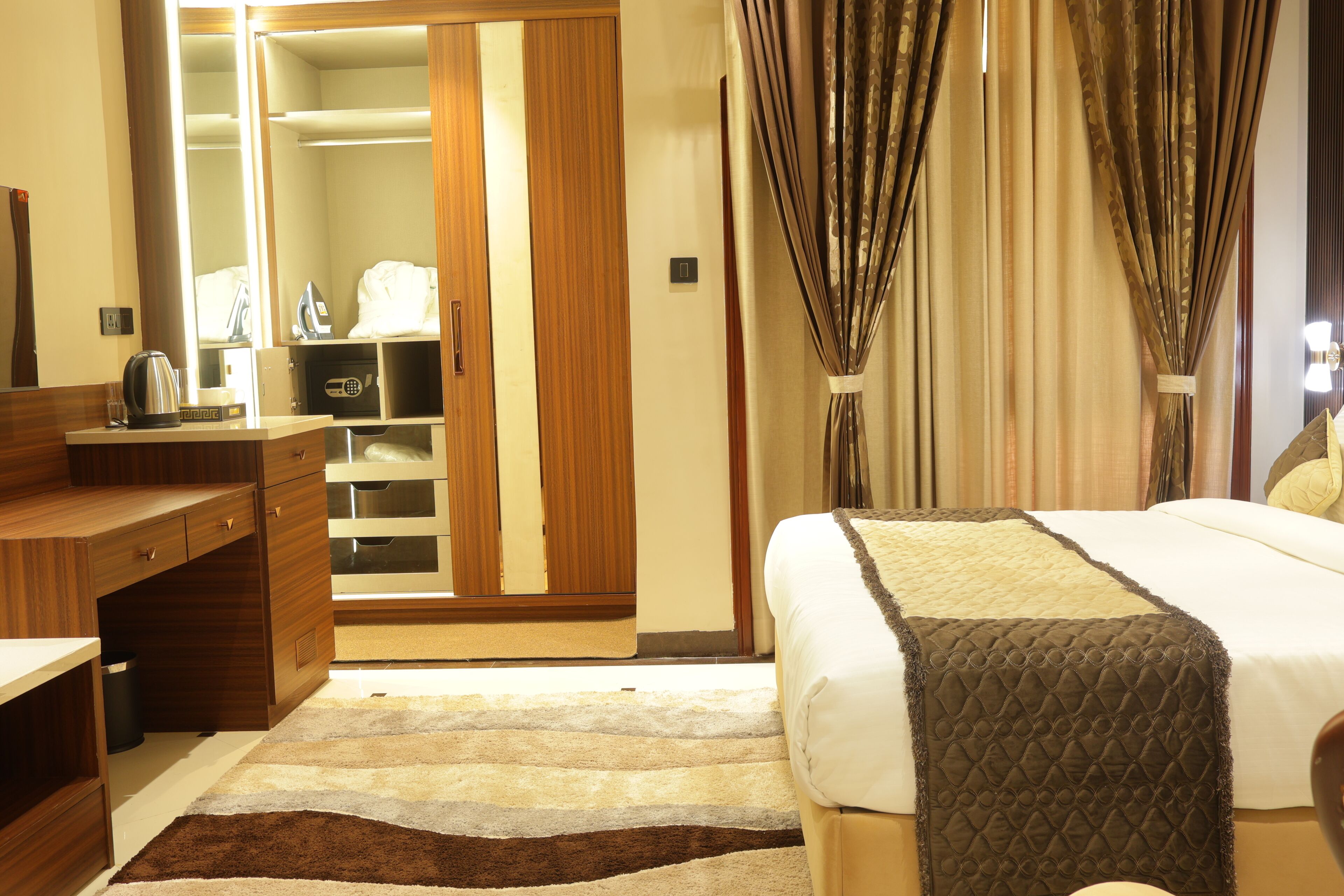 Una habitación de hotel con cama, escritorio, armario y baño.