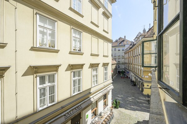 A narrow cobblestone street with buildings on either side, including a visible storefront with the sign "SALZAMI".