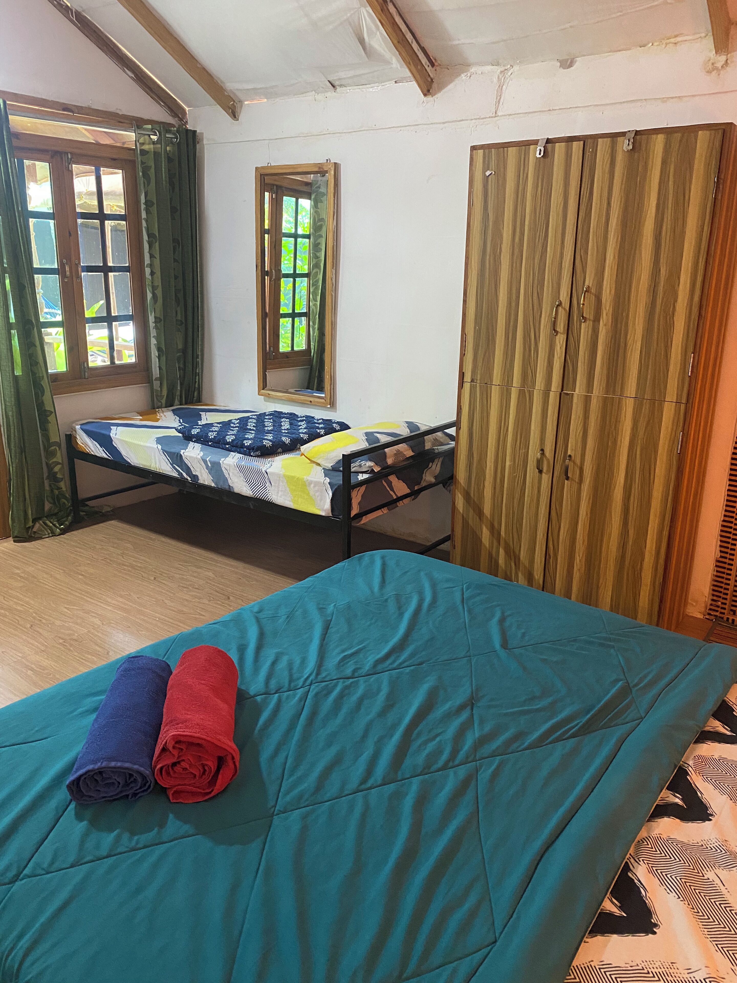 A room with a bed, a wardrobe, and a window.