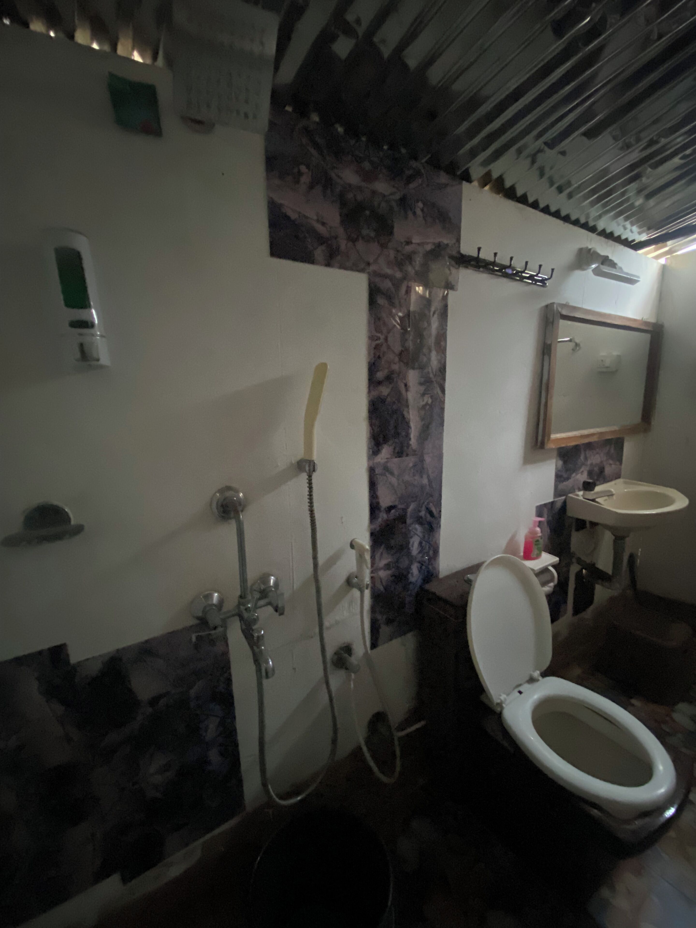 Ein Badezimmer mit Toilette, Waschbecken, Dusche und Marmorwand.