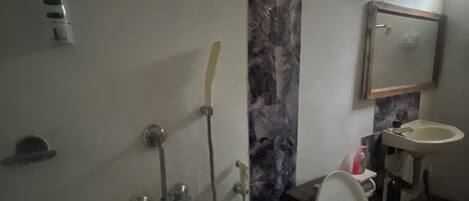 Ein Badezimmer mit Toilette, Waschbecken, Dusche und Marmorwand.