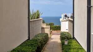 Ein schmaler Pfad führt zu einem Balkon mit Blick aufs Meer.