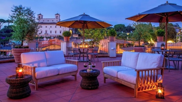 An outdoor seating area with wicker furniture, umbrellas, and lanterns. - The Inn at the Spanish Steps Luxury Collection - Spanish Steps Suites (Rome)