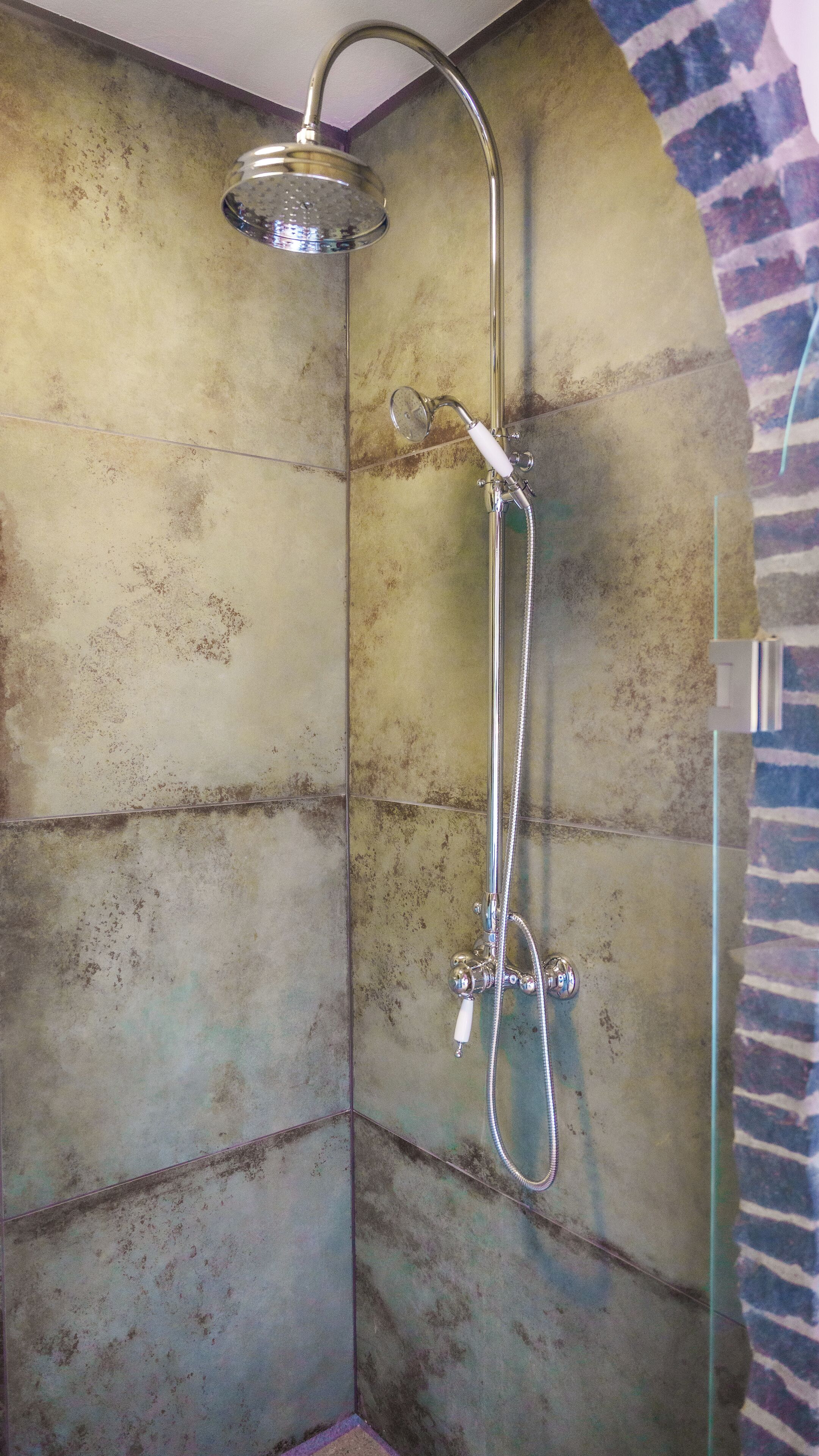 A shower with a handheld showerhead and a handheld sprayer.