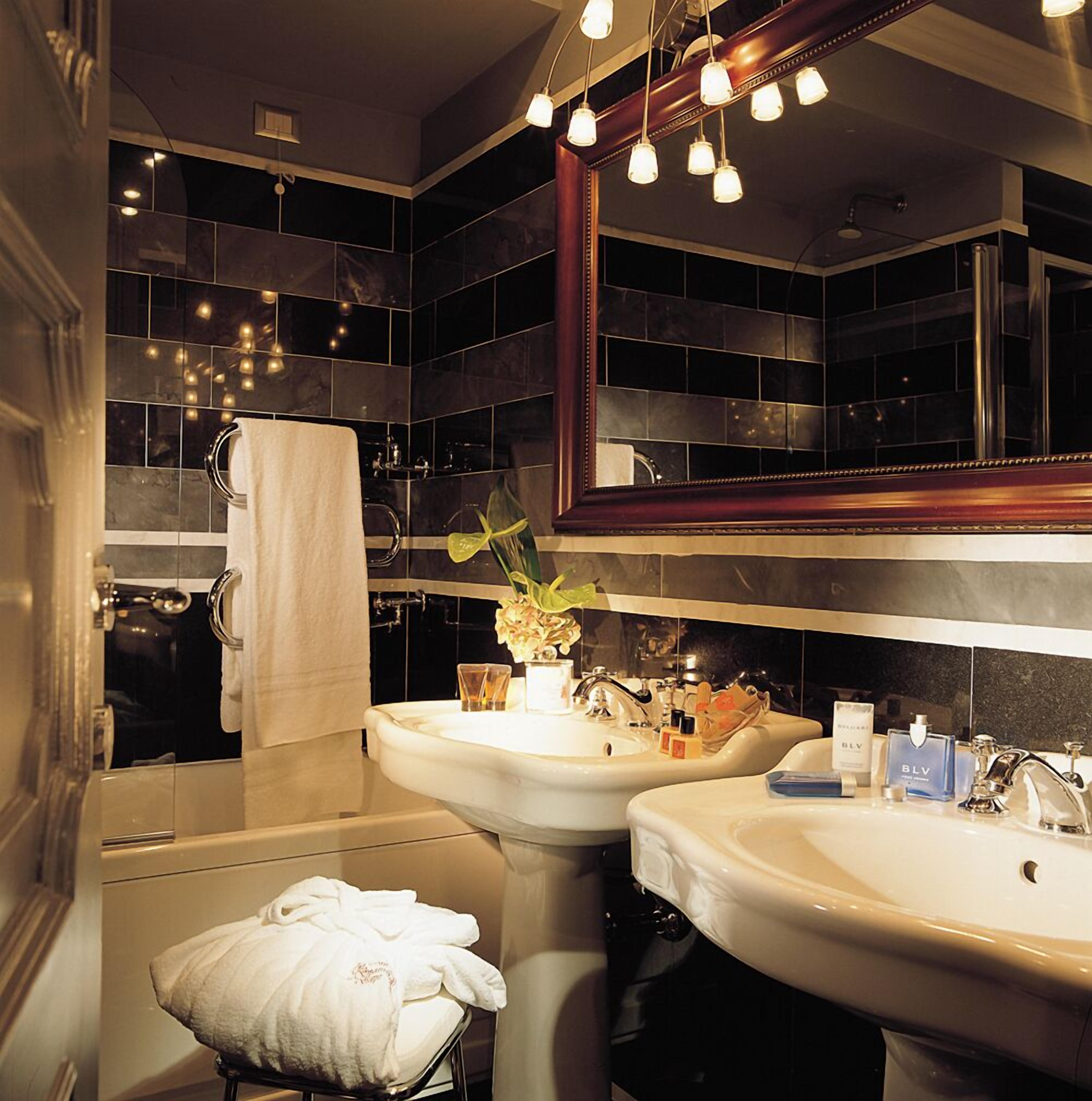 Ein modernes Badezimmer mit zwei Waschbecken, einem großen Spiegel und einer Badewanne.