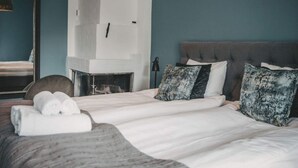 A bedroom with a bed, a fireplace, and a mirror. - 4 Star Holiday Home in Hisings Backa (Hisings Backa)