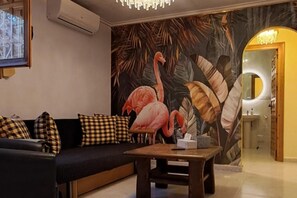 A living room with a sofa, a coffee table, and a mural of flamingos on the wall. - Adults Only Exclusive Mediterranean Private Escape (San Fulgencio)