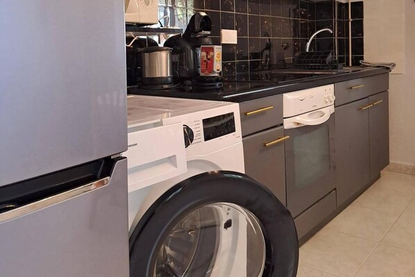 A compact kitchen with a built-in washer and dryer, a stove, and a sink. - Adults Only Exclusive Mediterranean Private Escape (San Fulgencio)