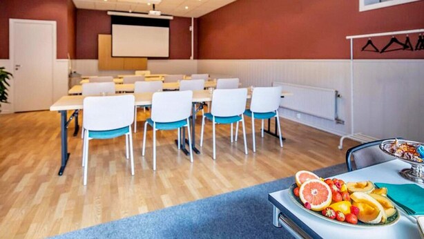 A conference room with white tables and chairs, a projector screen, and a fruit platter on the table. - 4 Star Holiday Home in Hisings Backa (Hisings Backa)