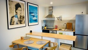 A modern kitchen with a wooden dining table, chairs, and a built-in oven. - Architect-Designed Studio Retreat in Prime South Hobart (South Hobart)