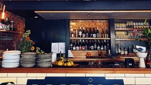 A bar area with a sign reading "LUPIN" and shelves stocked with various bottles and glasses. - Architect-Designed Studio Retreat in Prime South Hobart (South Hobart)