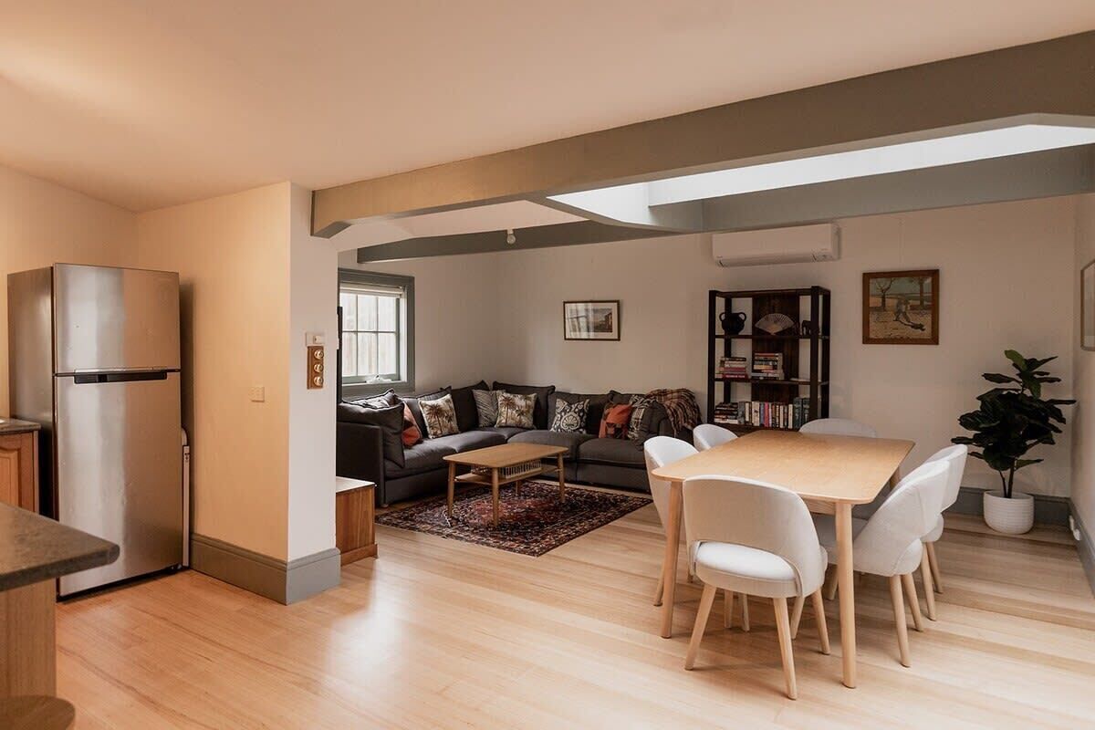 A modern living space with a kitchen, dining area, and a sofa set.