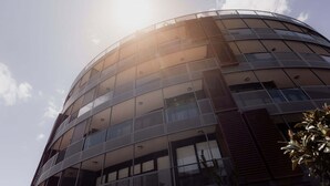 A modern building with a curved facade and large windows. - Fantastic CBD Apartment with Views (Hobart)