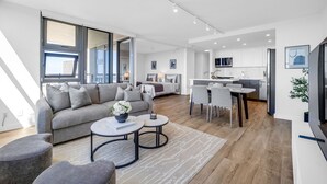 A modern living room with a sofa, coffee table, and dining area.