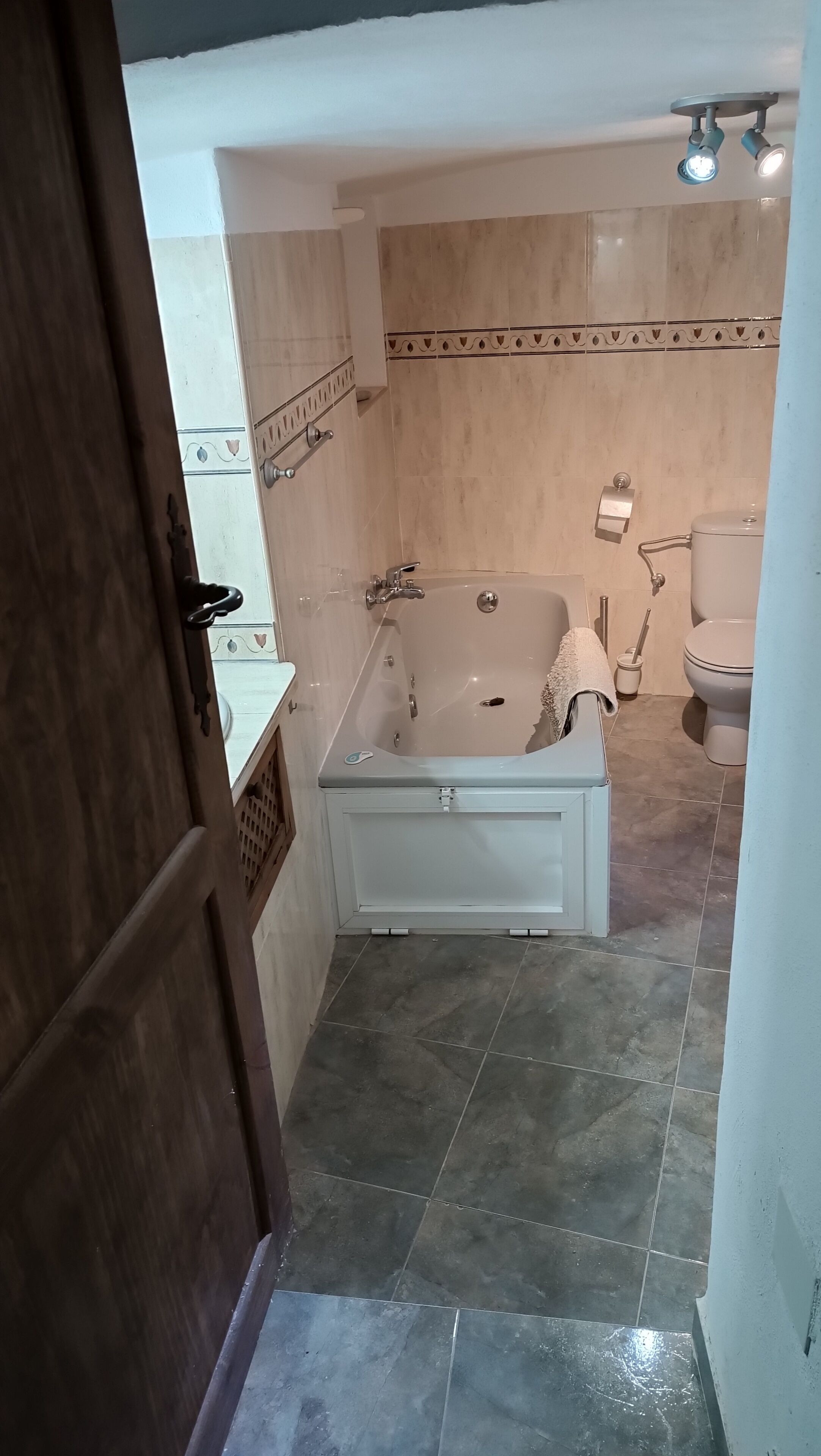 A bathroom with a bathtub, toilet, and shower area.