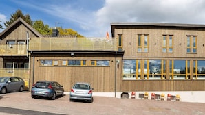 A modern building with a wooden facade, large windows, and a covered outdoor seating area. - 4 Star Holiday Home in Hisings Backa (Hisings Backa)