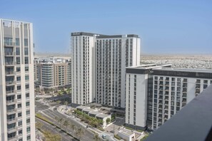 A high-rise building with multiple balconies and a clear view of the surrounding urban area.