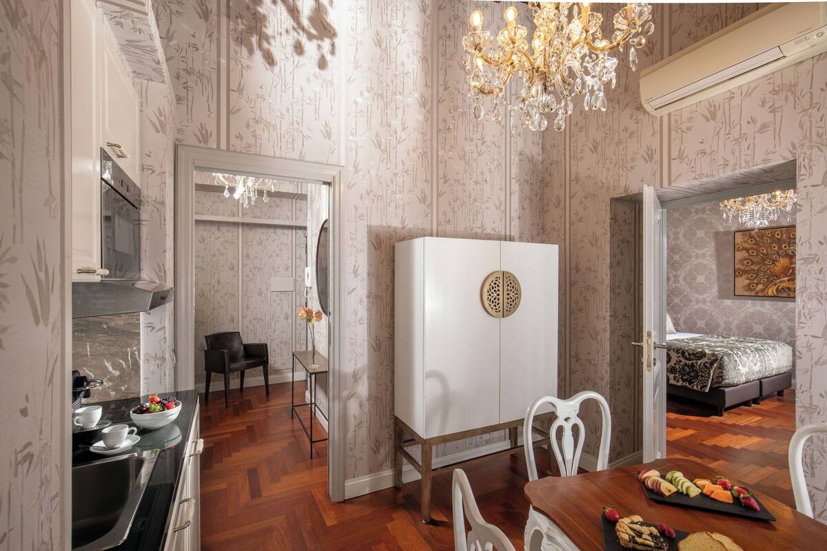 Habitación de hotel compacta con kitchenette, comedor y cama.