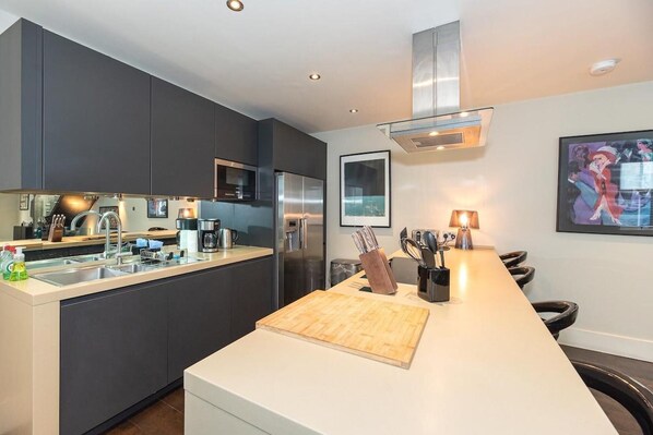 Enjoy cooking in this well-equipped kitchen with a central island, coffee station, and framed artwork.