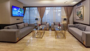 A modern living room with two sofas, a coffee table, and a TV mounted on the wall.