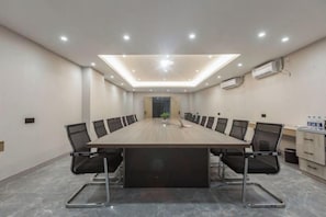 A conference room with a long table, chairs, and a ceiling light. - GYA Hotel (Jiaxing Nanhu Scenic Area Nanhu Tiandi) (Jiaxing)
